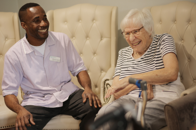 Nurse looking at senior woman using digital tablet